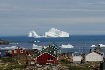 Schöne Landschaft vor dem Meer: 1 paar Häuser, auf dem Wasser sind kleine Eisberge