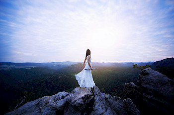 1 Frau in Weiß steht auf dem Gipfel eines Berges